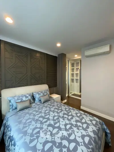 Modern bedroom with stylish decor and air conditioning in a contemporary apartment.