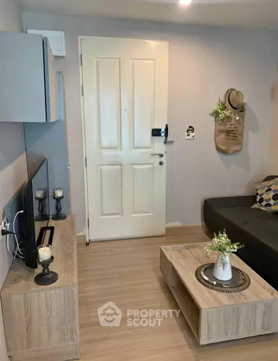 Cozy living room with modern decor and wooden flooring, featuring a stylish TV stand and comfortable seating.