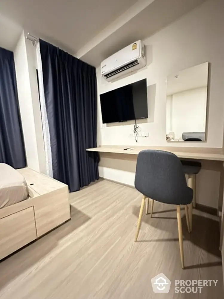 Modern bedroom with sleek design, featuring a wall-mounted TV and air conditioning.