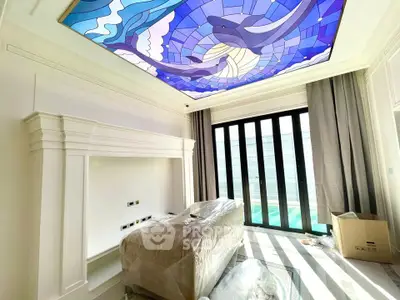 Luxurious room with stunning stained glass ceiling and large windows opening to a pool view.