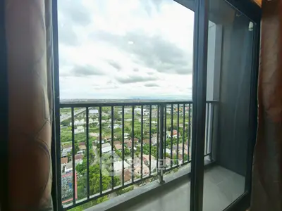 Stunning high-rise balcony view overlooking cityscape and greenery, perfect for urban living.