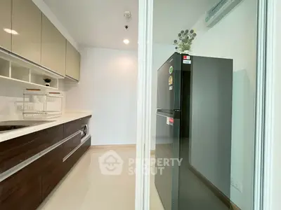 Modern kitchen with sleek cabinetry and spacious fridge in a contemporary apartment.