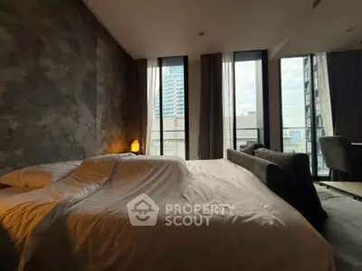 Modern bedroom with large windows and city view, featuring stylish decor and comfortable bedding.