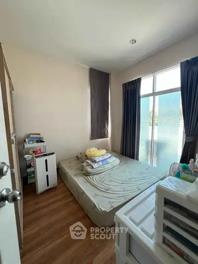 Cozy bedroom with natural light and minimalist decor, perfect for relaxation.