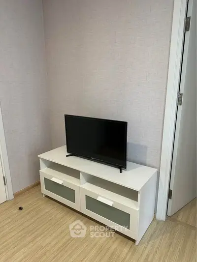 Modern living room corner with sleek TV stand and flat-screen TV, perfect for cozy entertainment setup.
