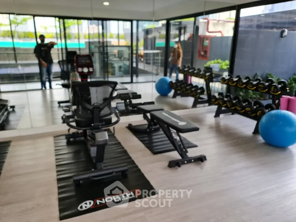 Modern gym with state-of-the-art equipment and mirrored walls in luxury apartment complex.