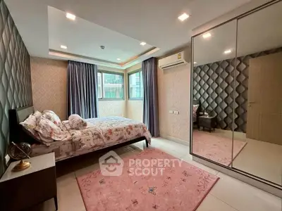 Spacious bedroom with modern decor and large mirrored wardrobe