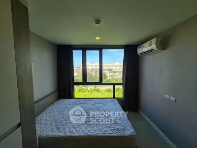 Modern bedroom with large window and air conditioning, offering a bright and inviting atmosphere.