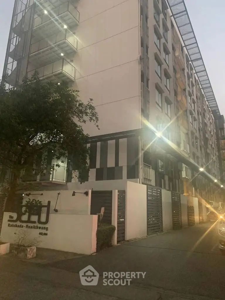 Modern apartment building exterior with sleek design and well-lit entrance.