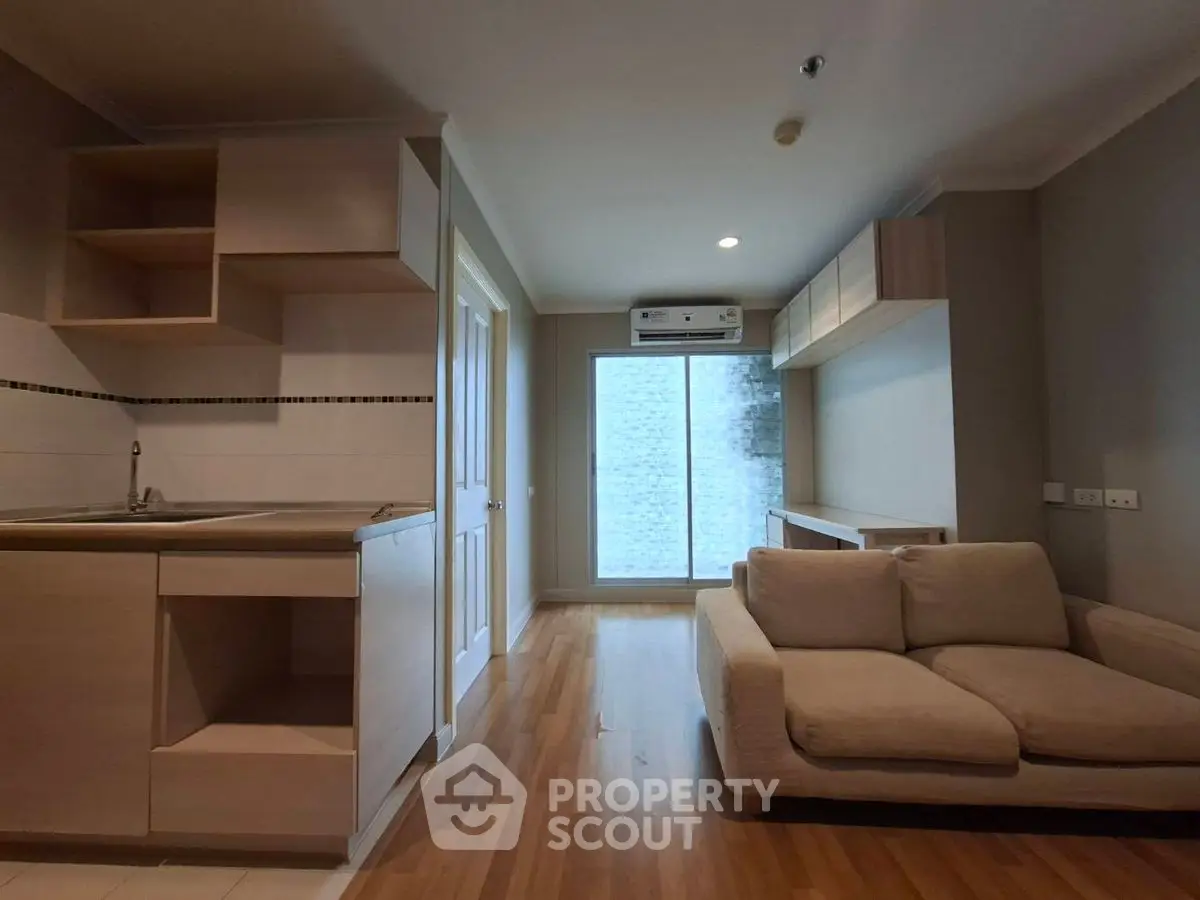 Modern open-plan living room with cozy sofa and sleek kitchen area