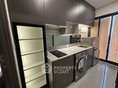Modern compact kitchen with sleek cabinetry and built-in appliances in a stylish apartment.
