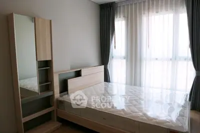 Modern bedroom with large window and stylish furniture, perfect for urban living.