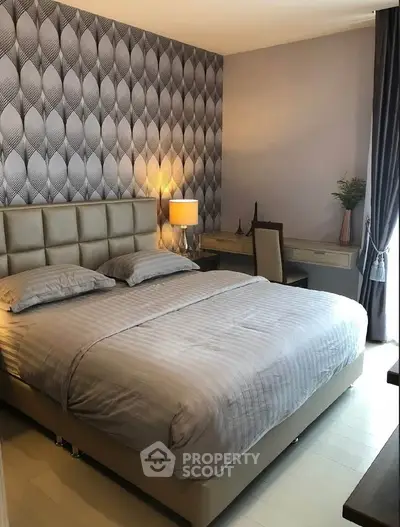 Elegant bedroom with modern decor and stylish wallpaper, featuring a cozy bed and a chic desk area.