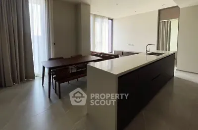 Spacious modern kitchen with island and dining area in elegant apartment.