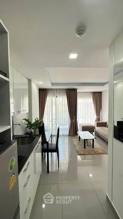 Modern open-layout kitchen and living room with sleek design and natural light.