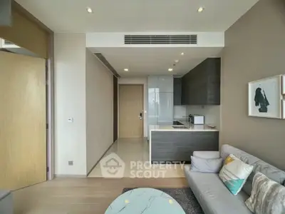 Modern living room with open kitchen, sleek design, and cozy seating area in a stylish apartment.