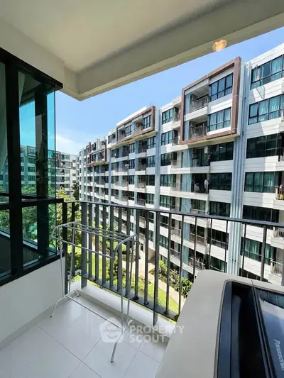 Spacious balcony with a view of modern apartment buildings, perfect for relaxation and enjoying the outdoors.