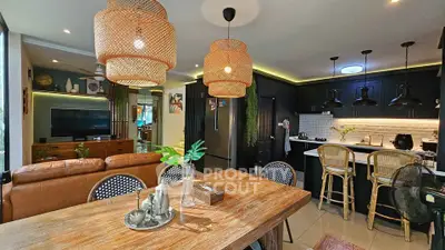 Stylish open-plan living room and kitchen with modern decor and natural lighting.
