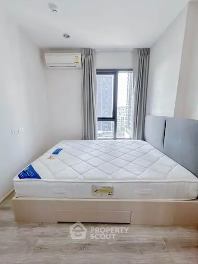 Modern bedroom with large window and air conditioning in a high-rise apartment.