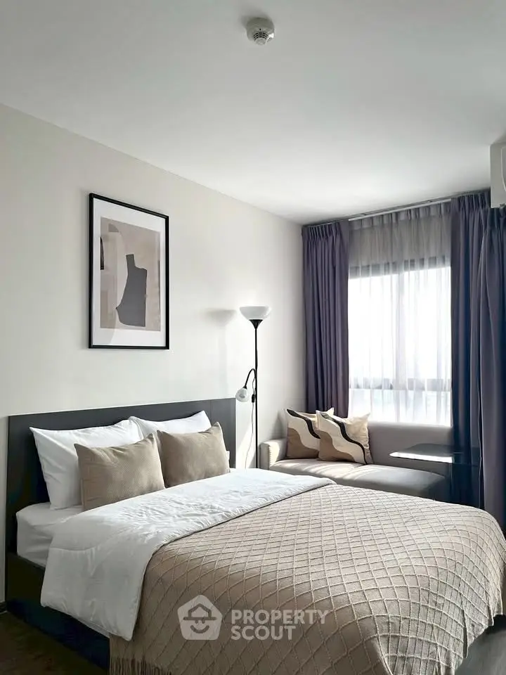Modern bedroom with stylish decor and natural light, featuring a cozy bed and elegant furnishings.
