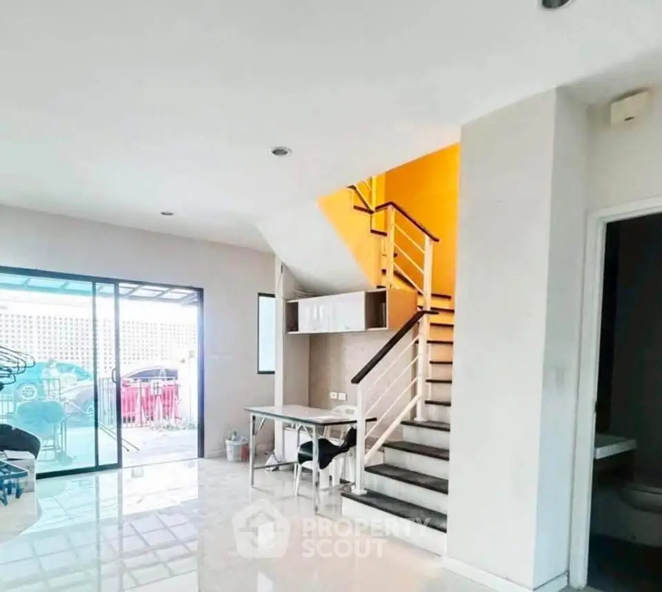 Modern interior with staircase and sliding glass doors leading to patio
