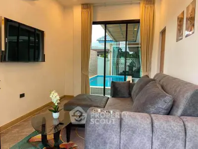 Modern living room with pool view, featuring sleek gray sofa and wall-mounted TV, perfect for relaxation.