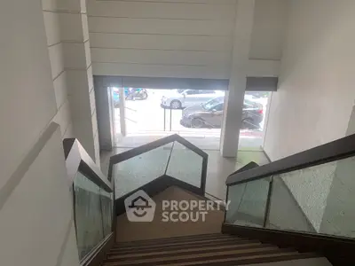Modern building entrance with stylish staircase and glass panels