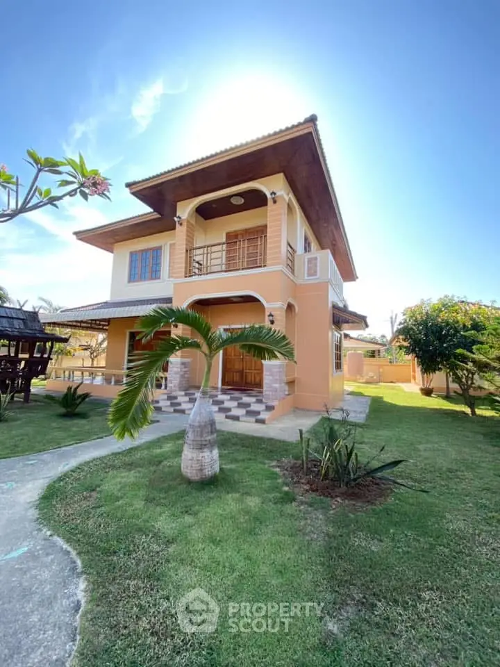 Charming two-story house with lush garden and inviting entrance