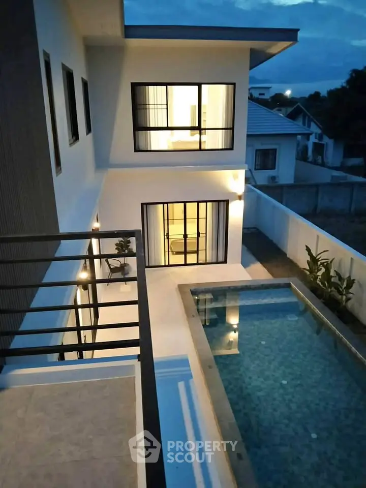 Modern two-story home with pool and elegant exterior lighting at dusk.