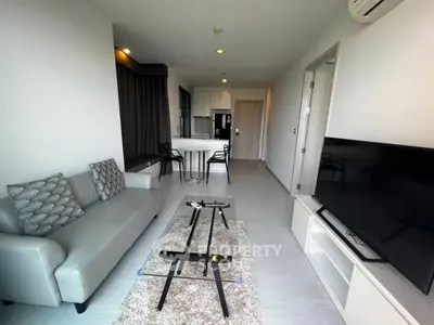 Modern living room with sleek furniture and open kitchen layout in a stylish apartment.