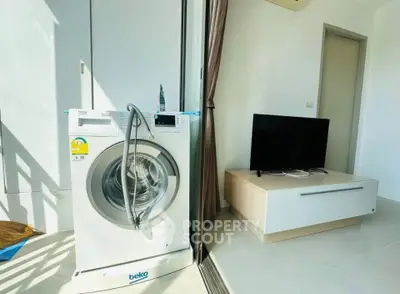 Modern apartment with washing machine and TV in bright living space