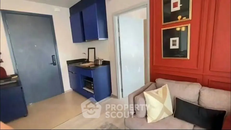 Modern apartment interior with stylish blue kitchen and cozy living area.