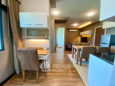 Modern open-plan living room with dining area and study nook, featuring stylish furniture and wooden flooring.