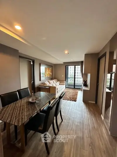 Modern open-plan living and dining area with stylish decor and city view.