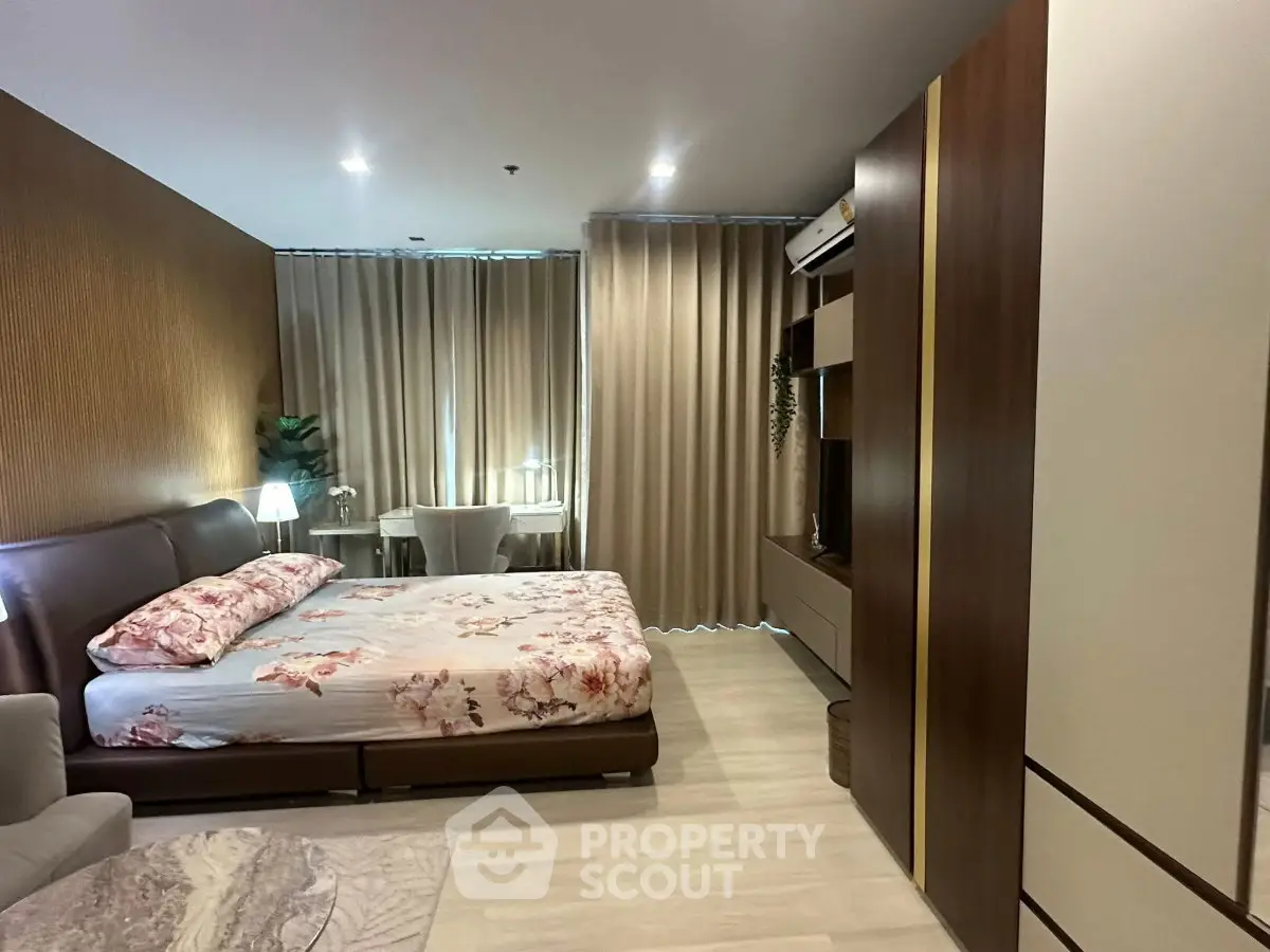 Luxurious bedroom with modern decor and ample natural light, featuring elegant furnishings and stylish curtains.