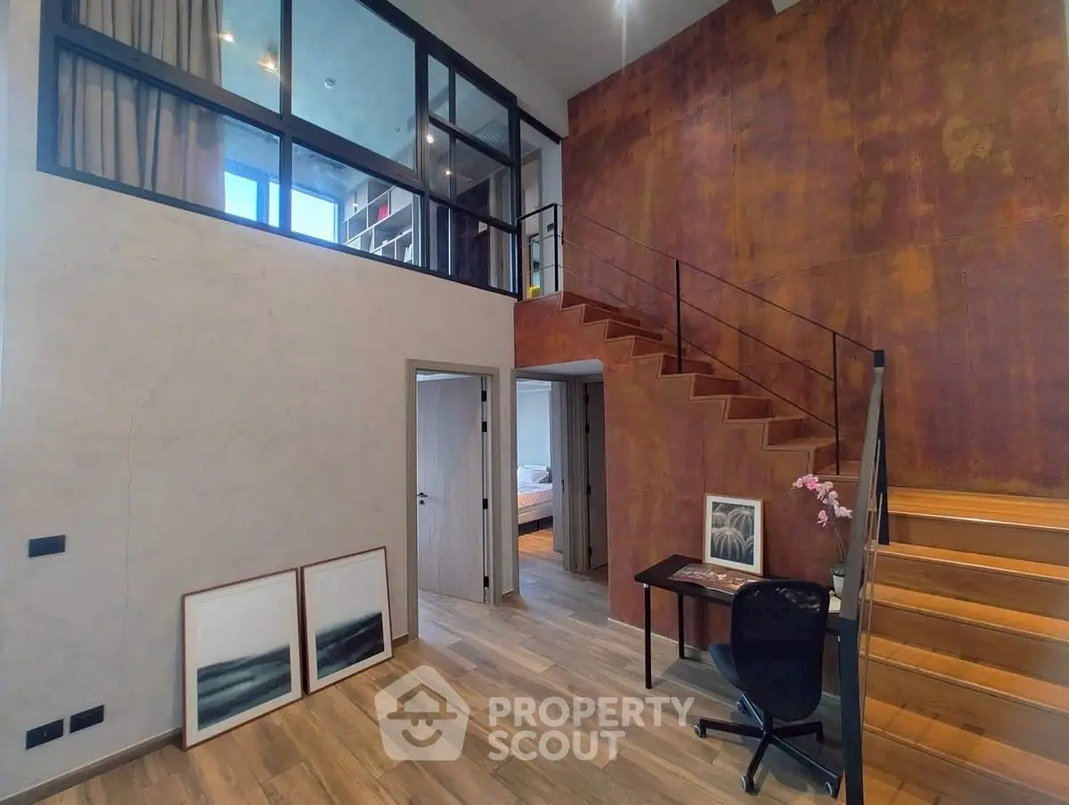 Modern loft-style interior with mezzanine and wooden staircase, perfect for urban living.