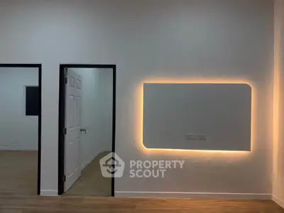 Modern interior with illuminated wall feature and wooden flooring