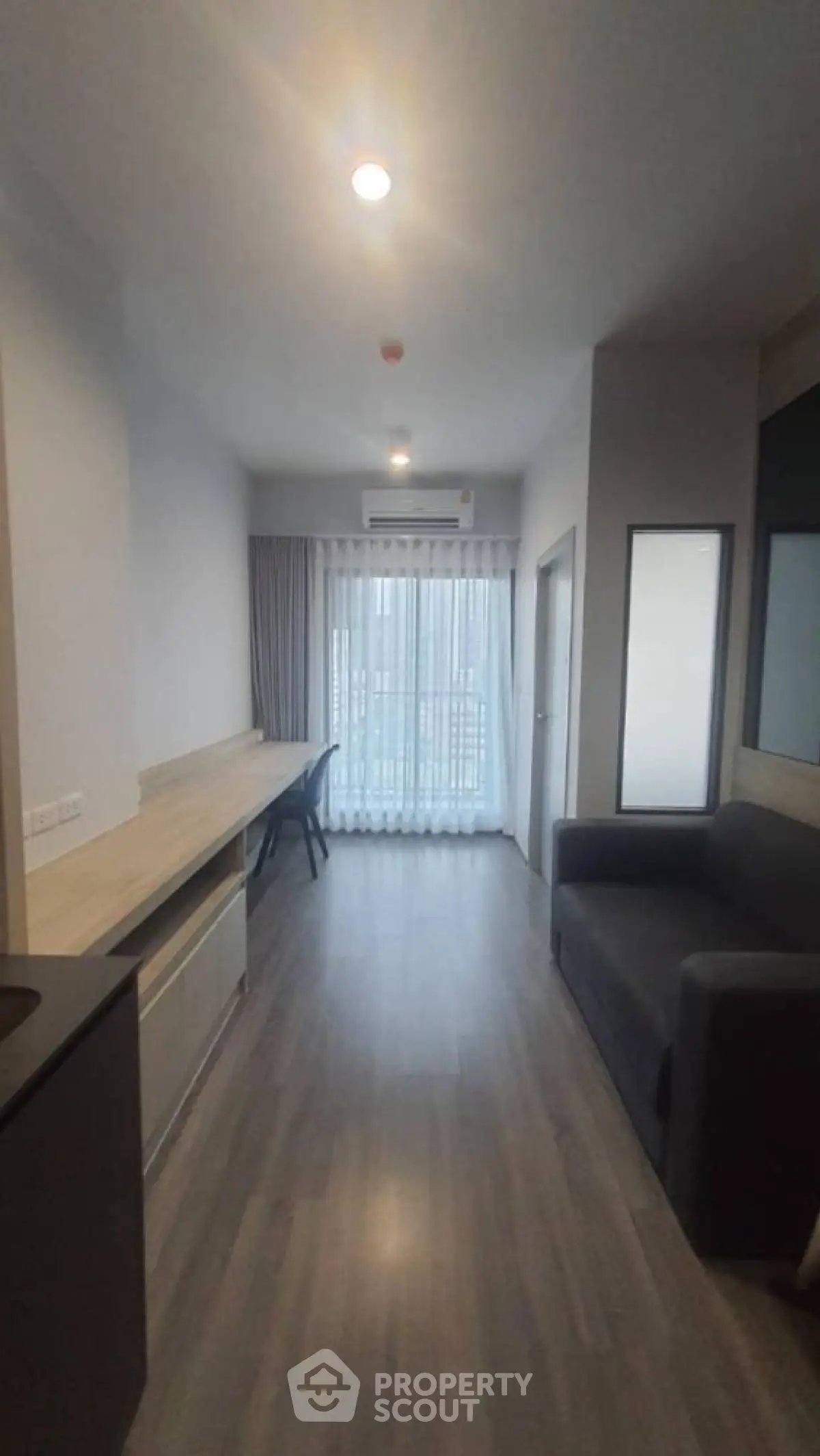 Modern living room with sleek design, featuring a large window and stylish furniture, perfect for urban living.