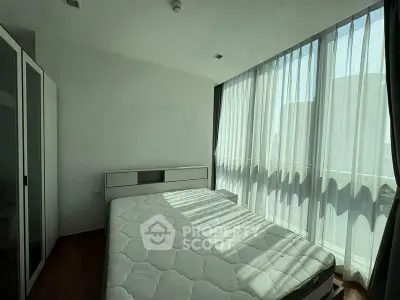 Bright bedroom with large windows and modern furnishings in a stylish apartment.