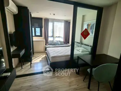 Modern bedroom with large windows and stylish decor in a cozy apartment.