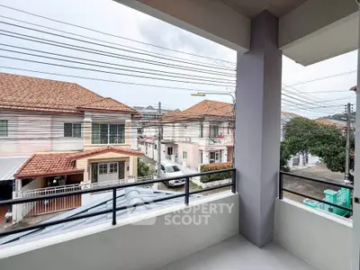 Charming balcony view of suburban neighborhood with tiled roofs and street view.