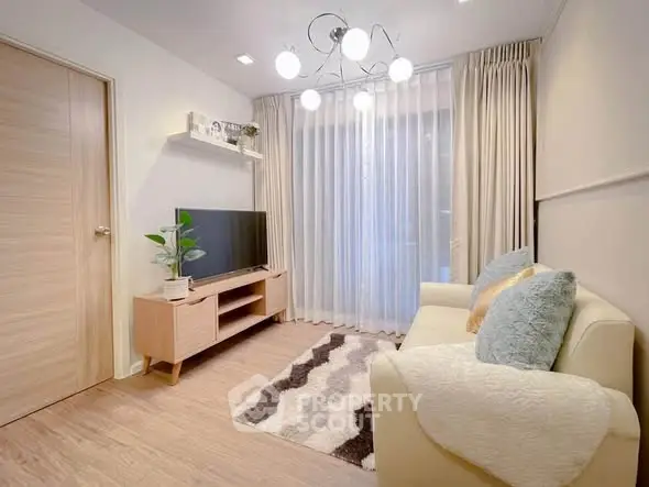 Cozy living room with modern decor, featuring a stylish sofa, TV, and elegant lighting.