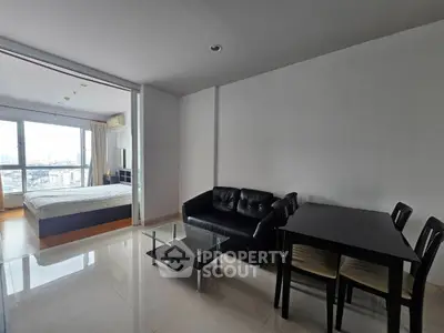 Spacious open-plan living room with modern furniture and city view, perfect for urban living.
