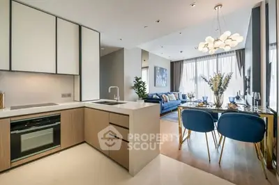 Modern open-layout kitchen and living room with stylish decor and natural light.