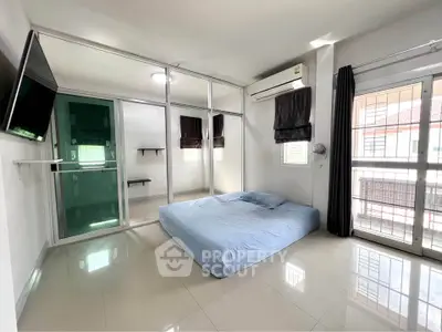 Spacious bedroom with modern glass partition and natural light