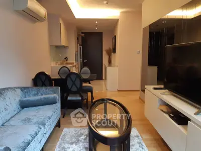 Stylish living room with modern furniture and open kitchen layout in a cozy apartment.