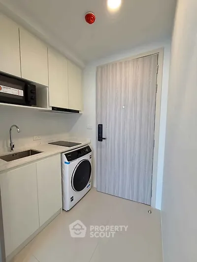 Modern compact kitchen with washing machine and sleek cabinetry