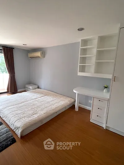 Spacious bedroom with built-in shelves and natural light in modern apartment