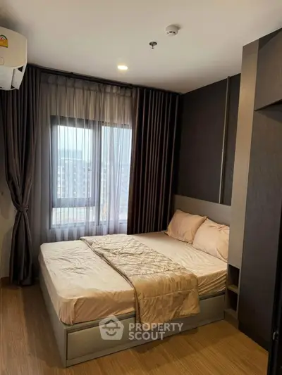 Cozy modern bedroom with large window and elegant curtains, perfect for relaxation and comfort.