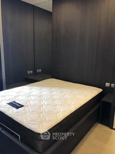 Modern bedroom with sleek dark wood paneling and comfortable mattress